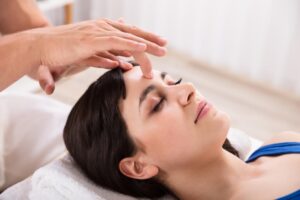 A woman trying acupressure practice for headaches