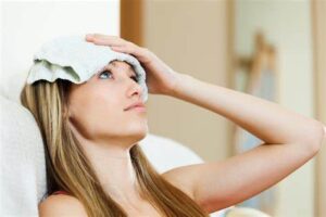 A woman using cold compress for headaches relief 